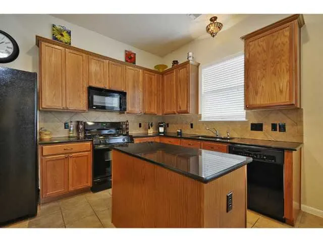 a kitchen with stainless steel appliances granite countertop a sink stove and microwave