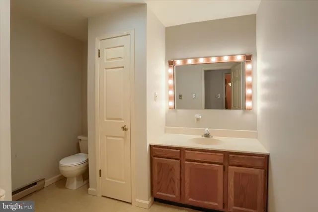 a bathroom with a granite countertop sink toilet a large mirror and shower