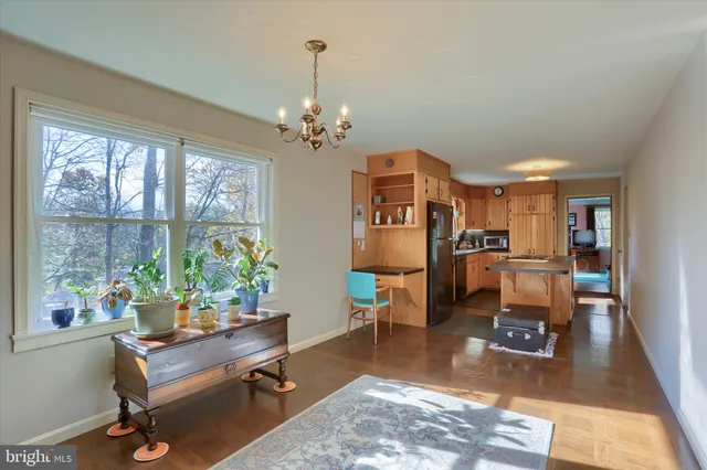 a living room with furniture and a dining table with kitchen view