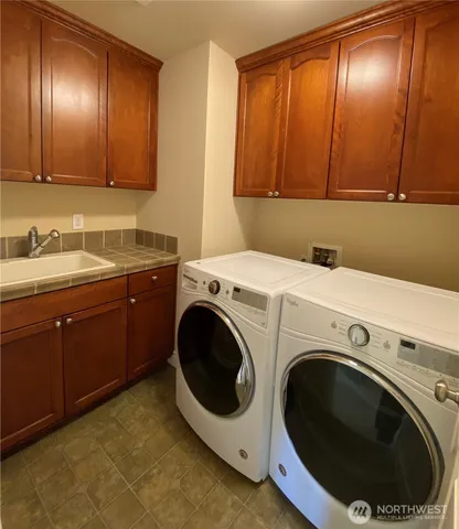 a utility room with sink dryer and washer
