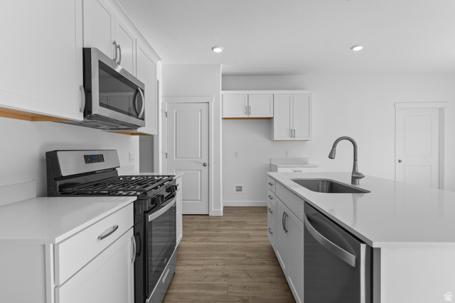 2823 North 710 West, Unit 16 Logan, UT 84321 - Photo 19 of 22 Kitchen featuring stainless steel appliances, an island with sink, dark wood-style flooring, white cabinets, and recessed lighting