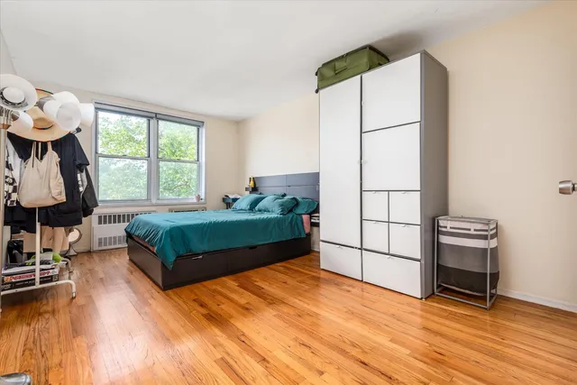 a bedroom with a bed a mirror and a window