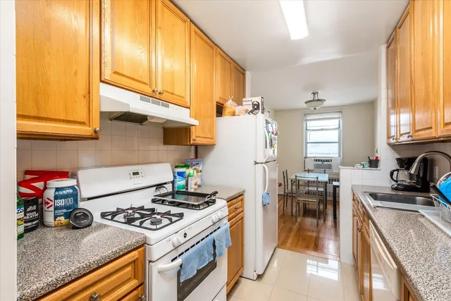 a kitchen with sink a stove and a refrigerator