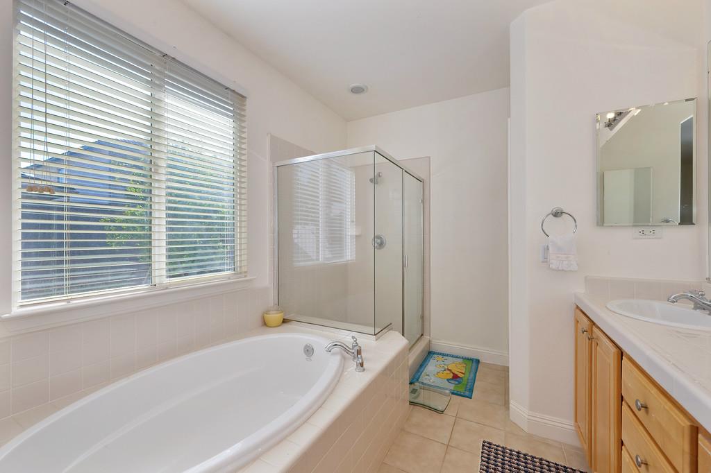 3930 Riley Anton Way Rancho Cordova, CA 95742 - Photo 36 of 45 a bathroom with a tub a sink and a window