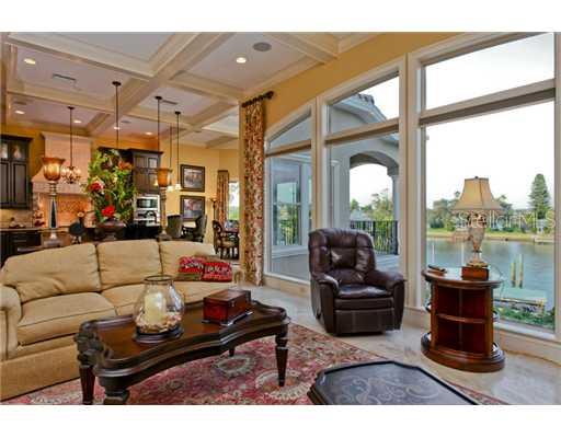 Living Room - Wonderful open living room  offers amazing waterfront views.  Note the impressive coffered ceilings and large hurricane impact casement windows with lovely wood casings.
