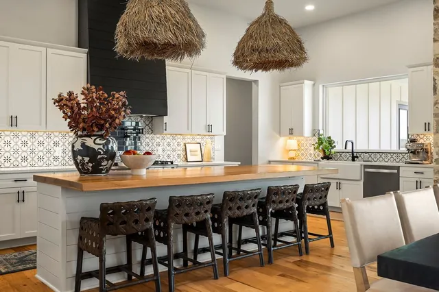 a kitchen with granite countertop a stove and a white cabinets
