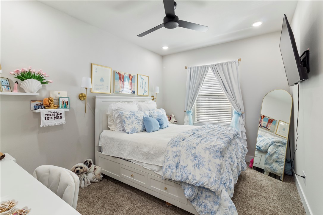 4078 Gunner Trail College Station, TX 77845 - Photo 11 of 33 a bedroom with a bed a flat screen tv and a couch