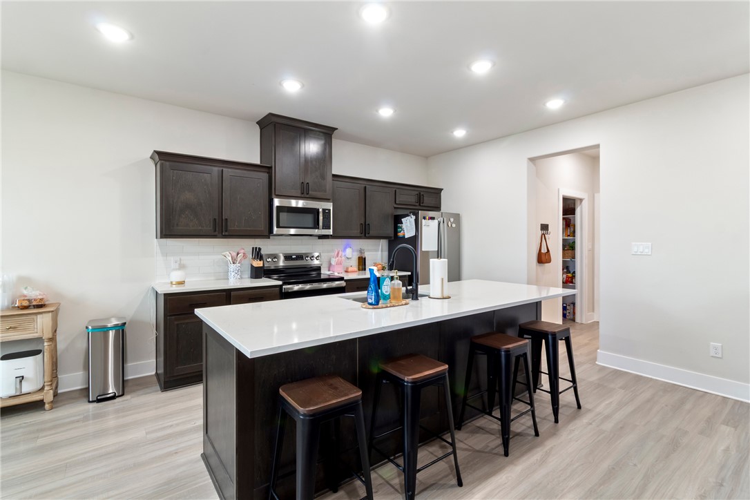 4078 Gunner Trail College Station, TX 77845 - Photo 5 of 33 a kitchen with kitchen island cabinets and wooden floor