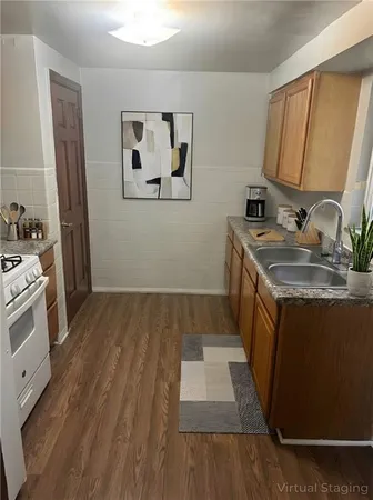 a kitchen with a sink and wooden floor