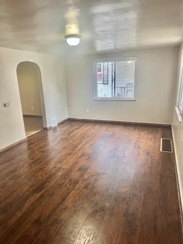 a view of a livingroom with wooden floor and a window