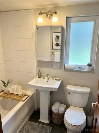 a bathroom with a toilet sink and mirror