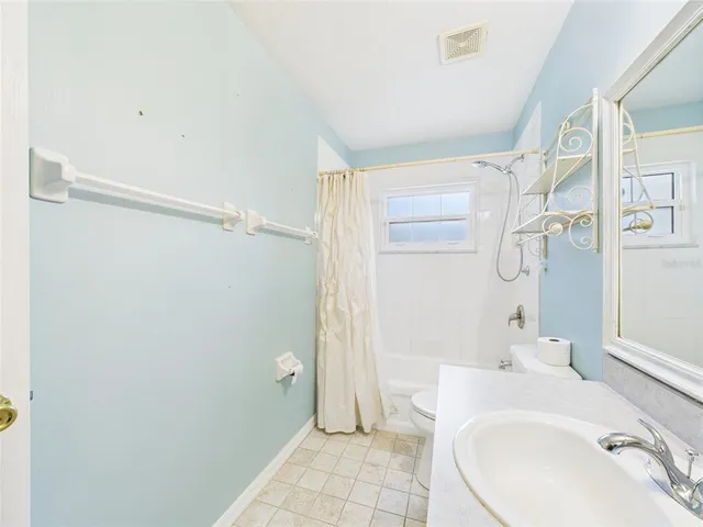 a bathroom with a sink mirror and shower