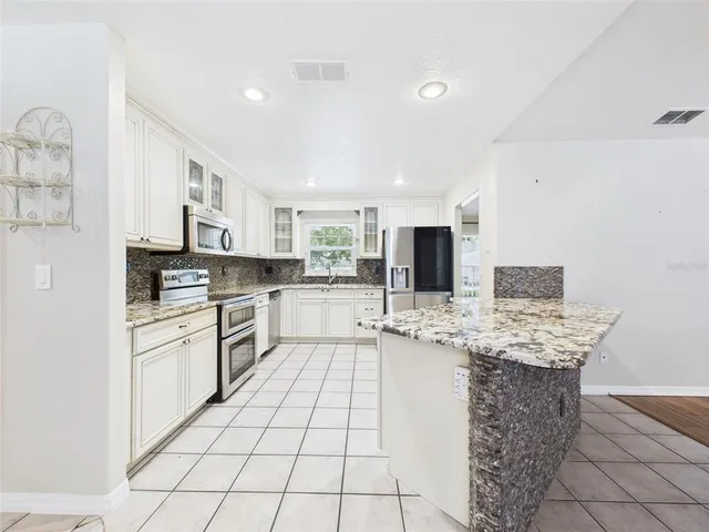 a kitchen with stainless steel appliances granite countertop a sink and cabinets