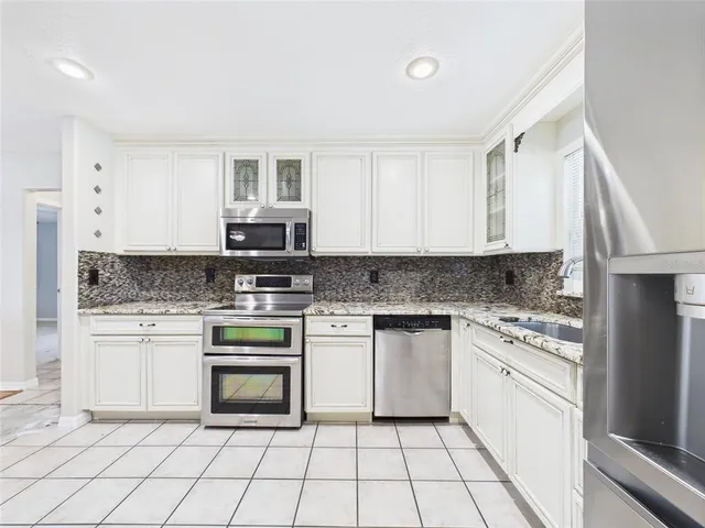 a large kitchen with kitchen island a sink stainless steel appliances and cabinets