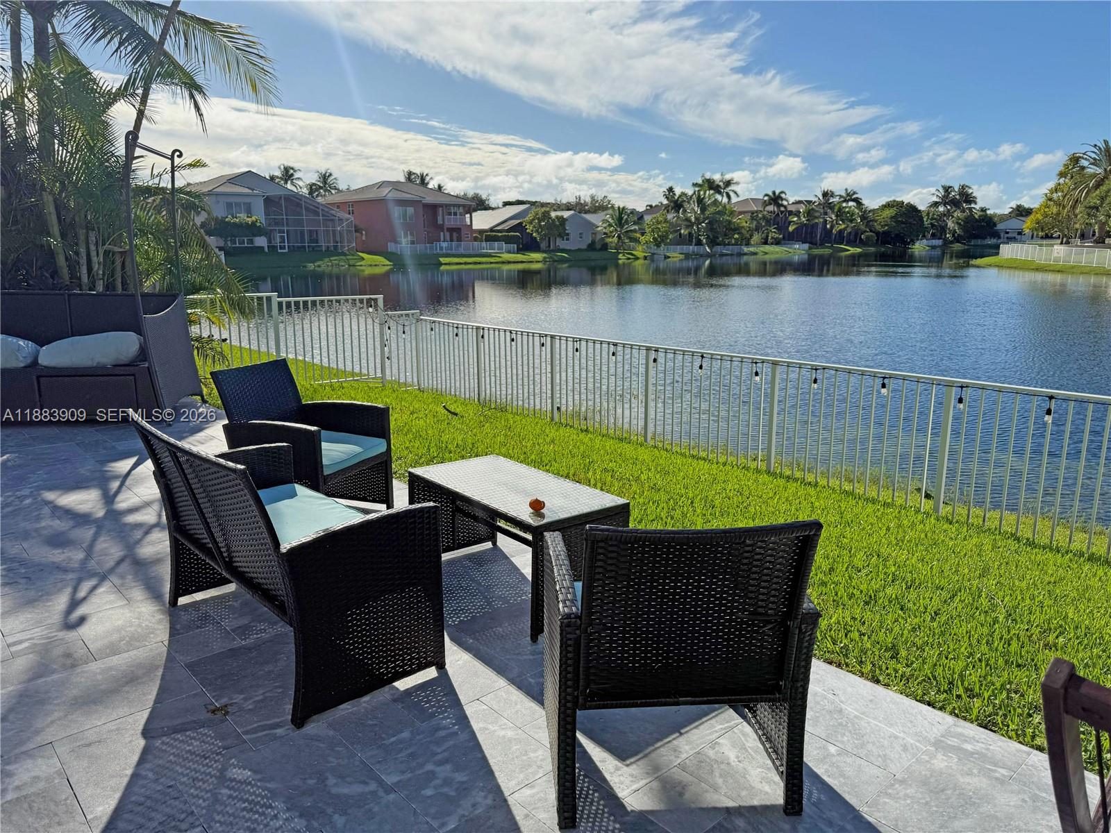 18560 Southwest 44th Street Miramar, FL 33029 - Photo 11 of 16 a view of a lake with table and chairs floor to ceiling window