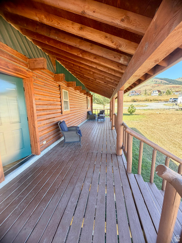 358 Maple Drive Fish Haven, ID 83287 - Photo 10 of 49 Expansive covered porch featuring wood-finish decking, log railings, and a wood-paneled ceiling