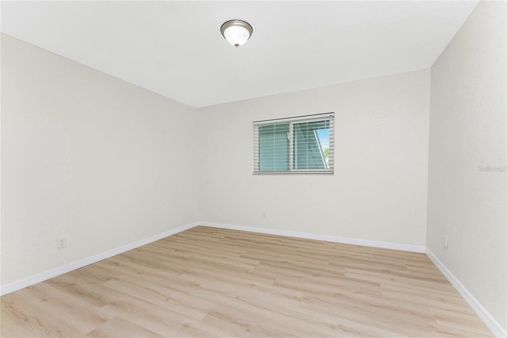 6800 Placida Road, Unit 228 Englewood, FL 34224 - Photo 15 of 45 an empty room with wooden floor and windows