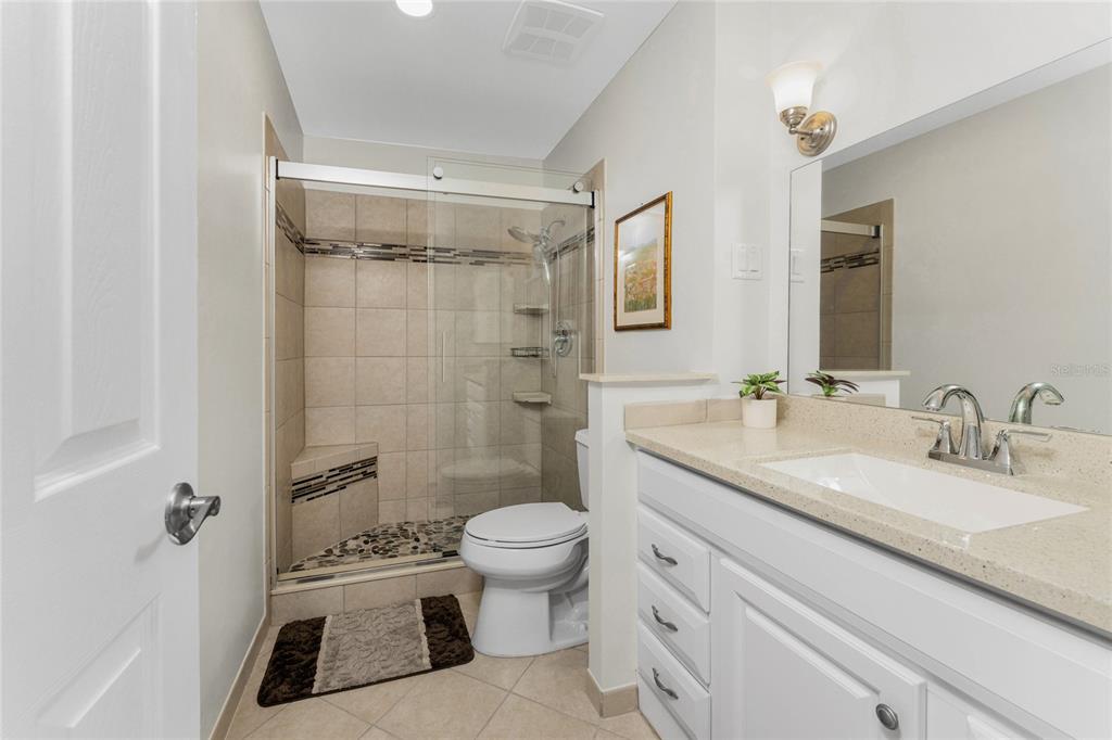 6800 Placida Road, Unit 228 Englewood, FL 34224 - Photo 24 of 45 a bathroom with a granite countertop sink toilet a mirror a vanity and shower