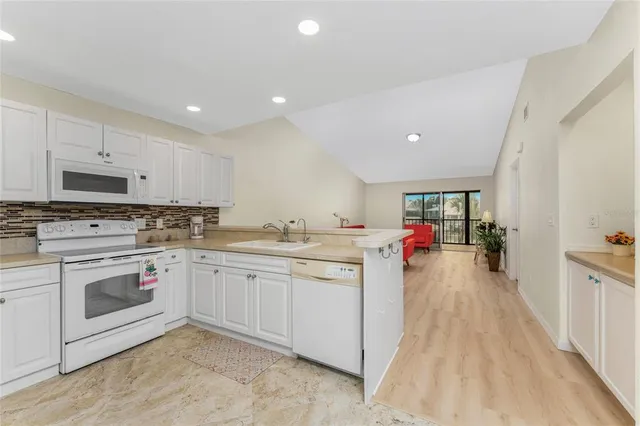 a kitchen with sink cabinets and flat screen tv
