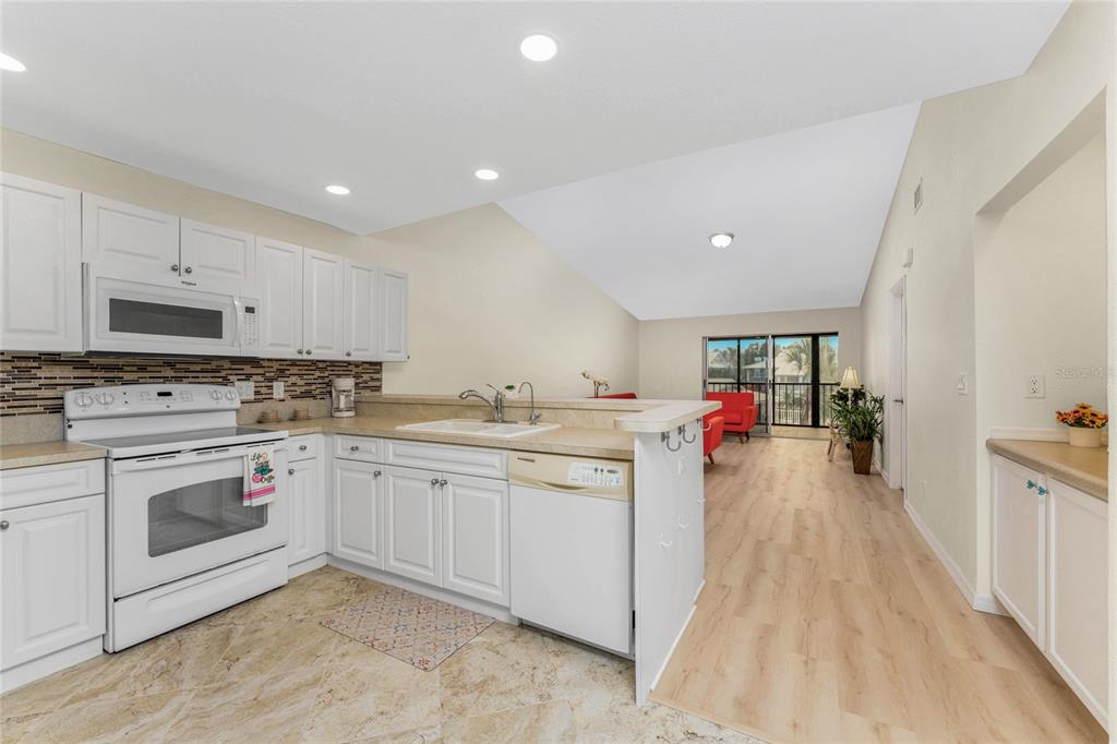 6800 Placida Road, Unit 228 Englewood, FL 34224 - Photo 5 of 45 a kitchen with sink cabinets and flat screen tv