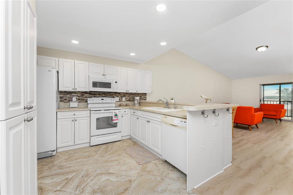 6800 Placida Road, Unit 228 Englewood, FL 34224 - Photo 7 of 45 a kitchen with white cabinets and white appliances
