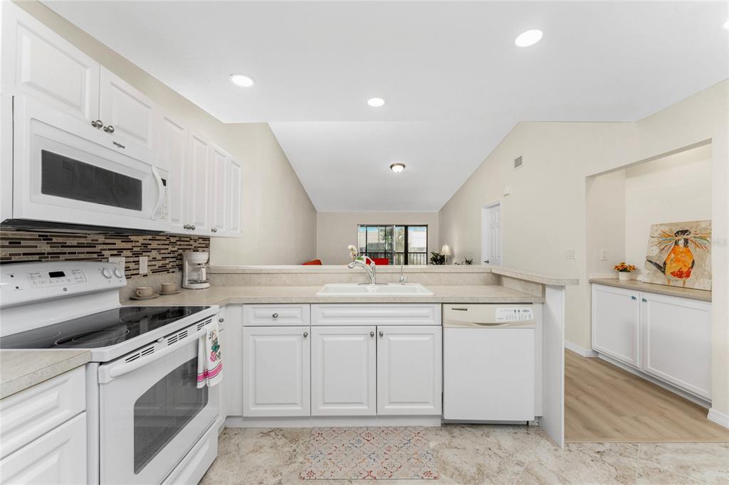 6800 Placida Road, Unit 228 Englewood, FL 34224 - Photo 10 of 45 a kitchen with a stove top oven sink and cabinets