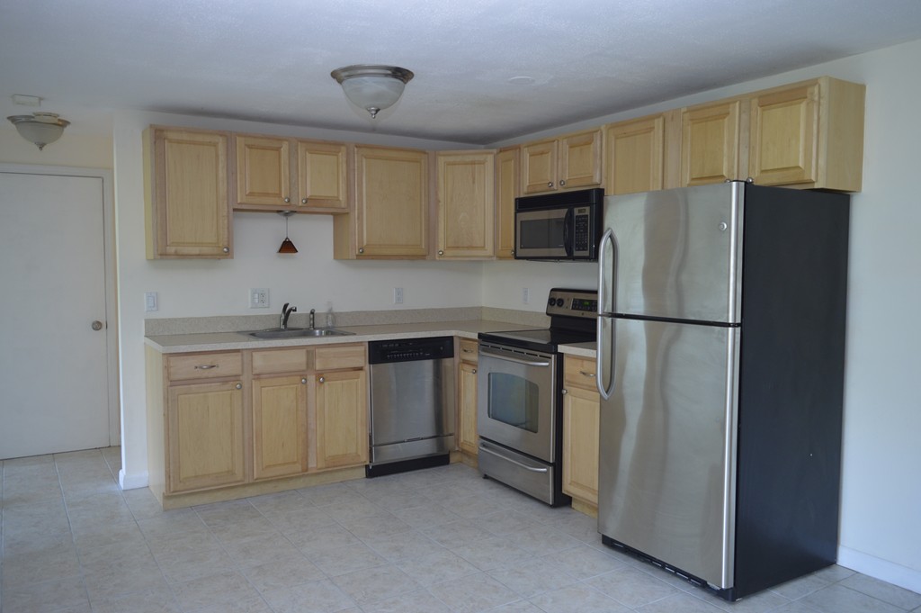 222 Stackpole Street, Unit 15 Lowell, MA 01852 - Photo 9 of 16 a kitchen with cabinets stainless steel appliances and a counter space