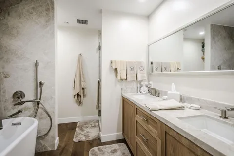 a bathroom with a granite countertop sink mirror and a bathtub
