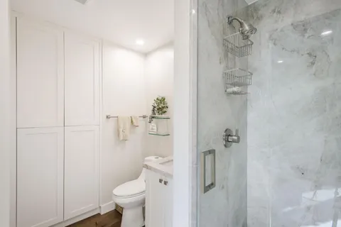 a bathroom with a granite countertop toilet and a shower