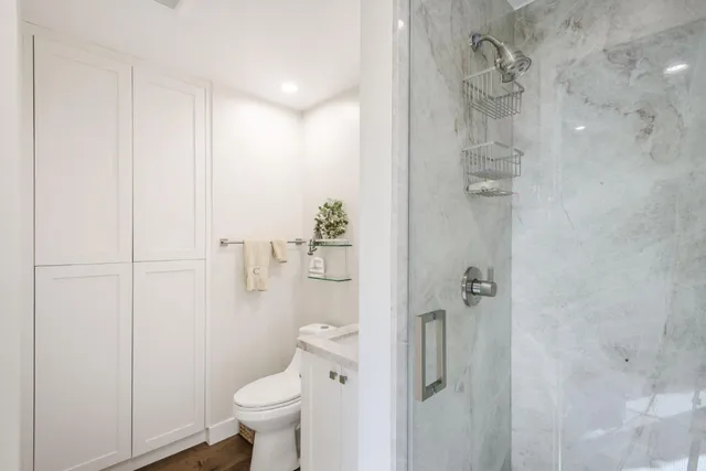 a bathroom with a granite countertop toilet and a shower