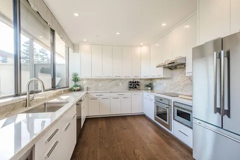a kitchen with a sink stainless steel appliances and window
