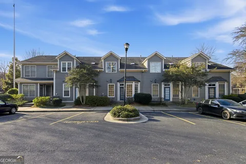 a front view of a building with cars parked