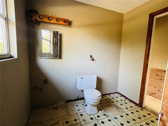 a bathroom with a toilet and a shower curtain
