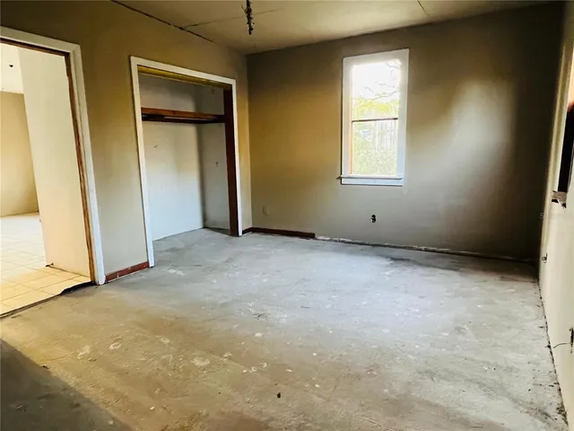 an empty room with windows and closet