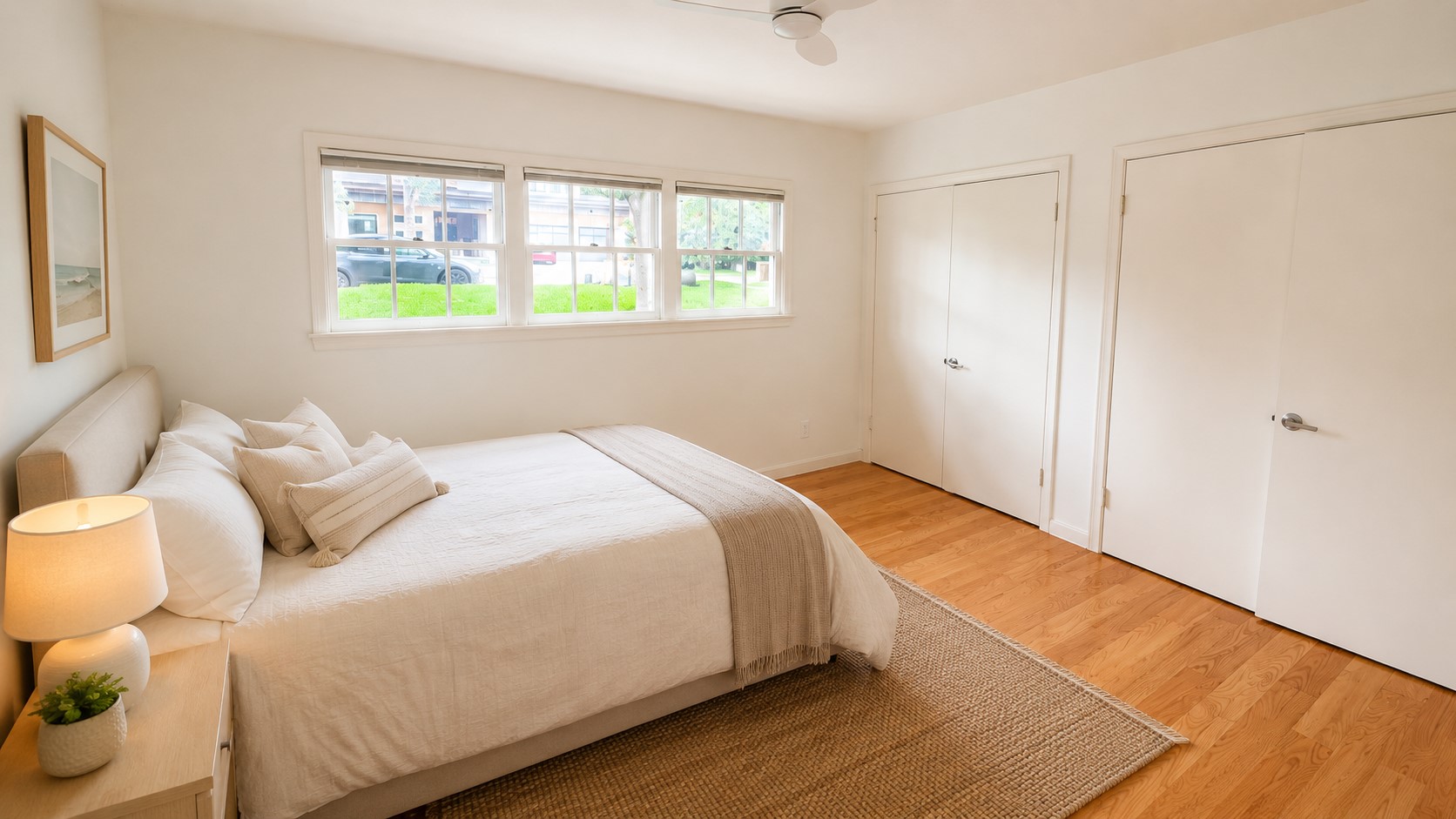 405 Ridgewood Road Austin, TX 78746 - Photo 14 of 22 Bright interior featuring multiple windows, wood-finish flooring, a ceiling fan, and two closed storage closets