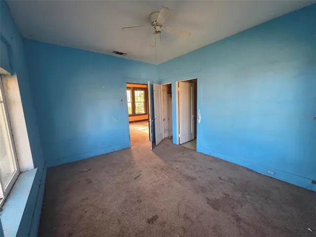 an empty room with windows and cabinet