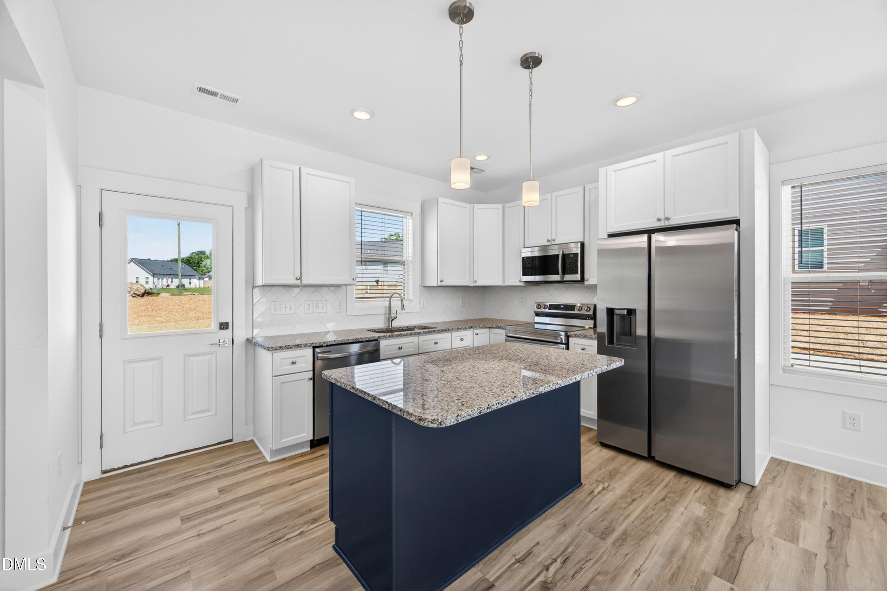 1256 Hurdle Mills Road Roxboro, NC 27573 - Photo 16 of 48 a kitchen with stainless steel appliances granite countertop a refrigerator a sink dishwasher a stove with white cabinets and wooden floor