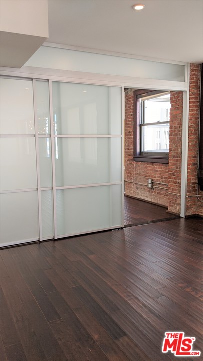460 South Spring Street, Unit 1005 Los Angeles, CA 90013 - Photo 12 of 46 a view of an empty room with wooden floor and a window