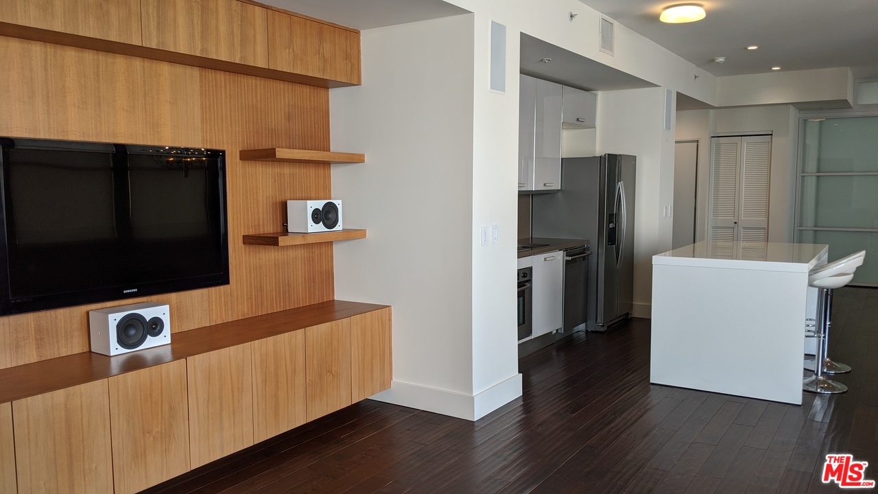 460 South Spring Street, Unit 1005 Los Angeles, CA 90013 - Photo 30 of 46 a living room with stainless steel appliances furniture a flat screen tv and a refrigerator