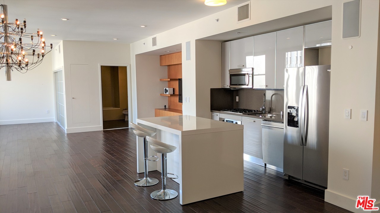 460 South Spring Street, Unit 1005 Los Angeles, CA 90013 - Photo 8 of 46 a living room with stainless steel appliances furniture refrigerator and a wooden floor