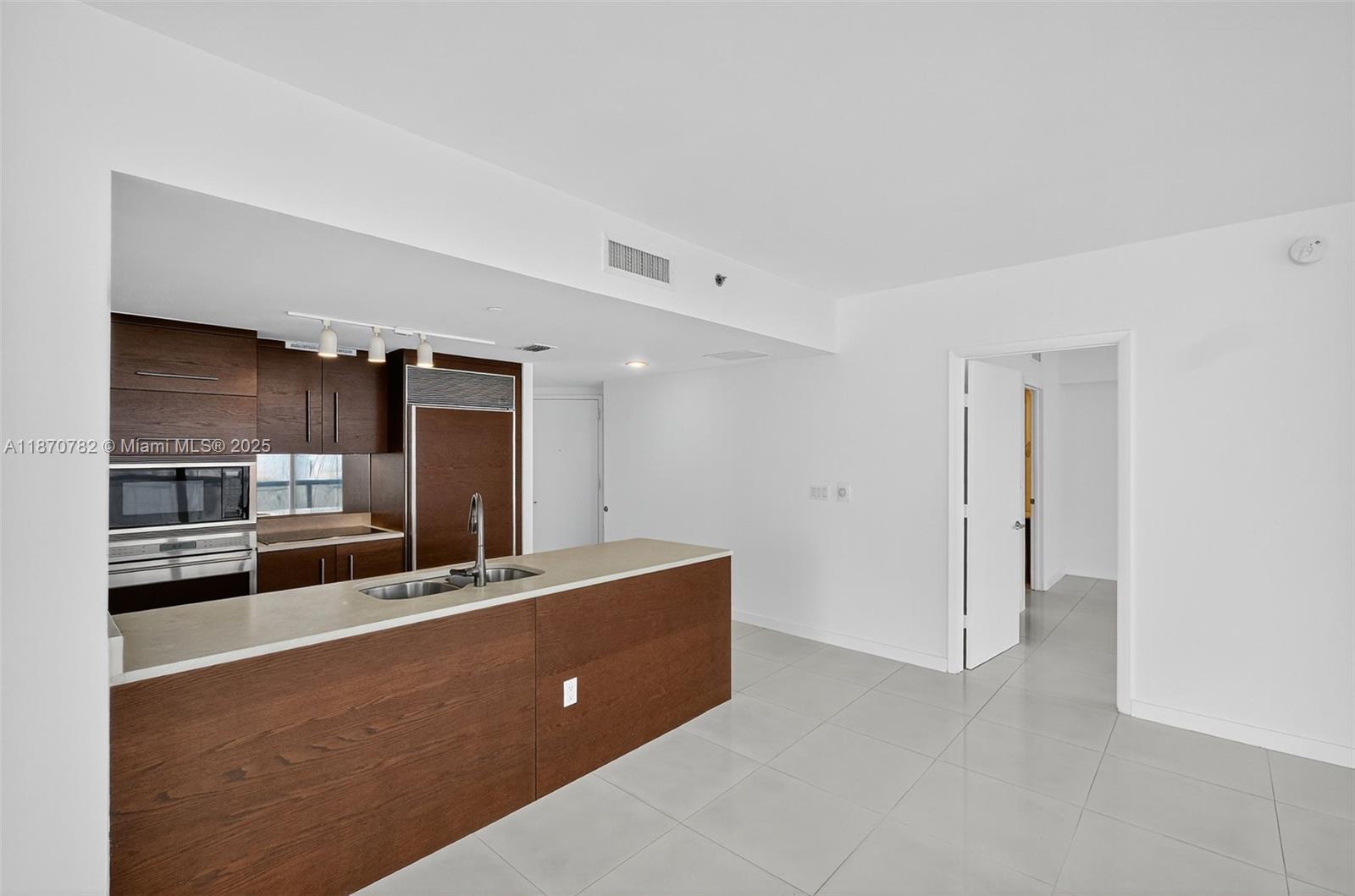 465 Brickell Avenue, Unit 2002 Miami, FL 33131 - Photo 11 of 44 a living room with stainless steel appliances kitchen island granite countertop a refrigerator and a stove top oven