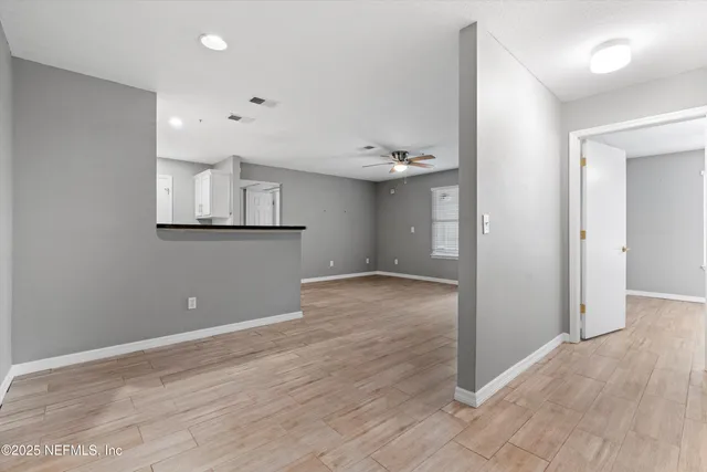 wooden floor in an empty room with a kitchen
