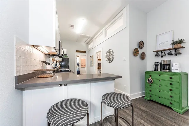 a kitchen with cabinets a sink and chairs