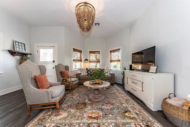 a living room with furniture a flat screen tv and a window