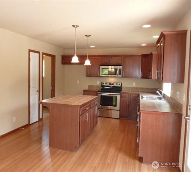 2340 Schley Boulevard Bremerton, WA 98310 - Photo 4 of 9 a kitchen with stainless steel appliances granite countertop a stove a sink and a refrigerator