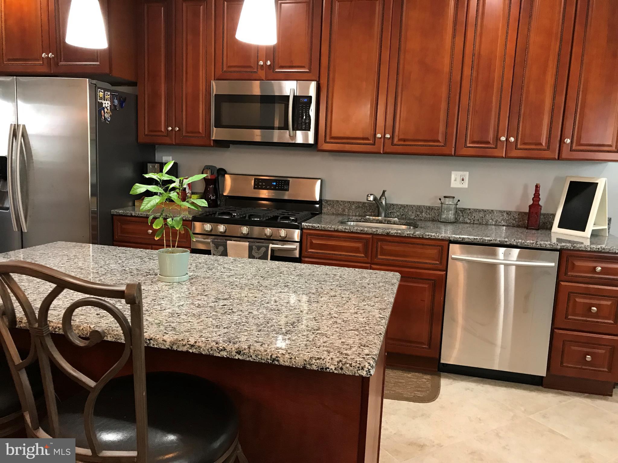 223 Westowne Road Baltimore, MD 21229 - Photo 11 of 21 a kitchen with stainless steel appliances granite countertop a stove refrigerator sink and microwave