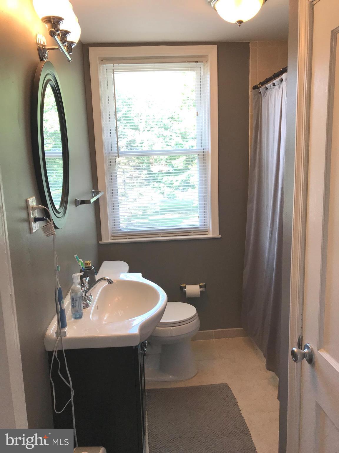 223 Westowne Road Baltimore, MD 21229 - Photo 12 of 21 a bathroom with a sink a toilet and a mirror