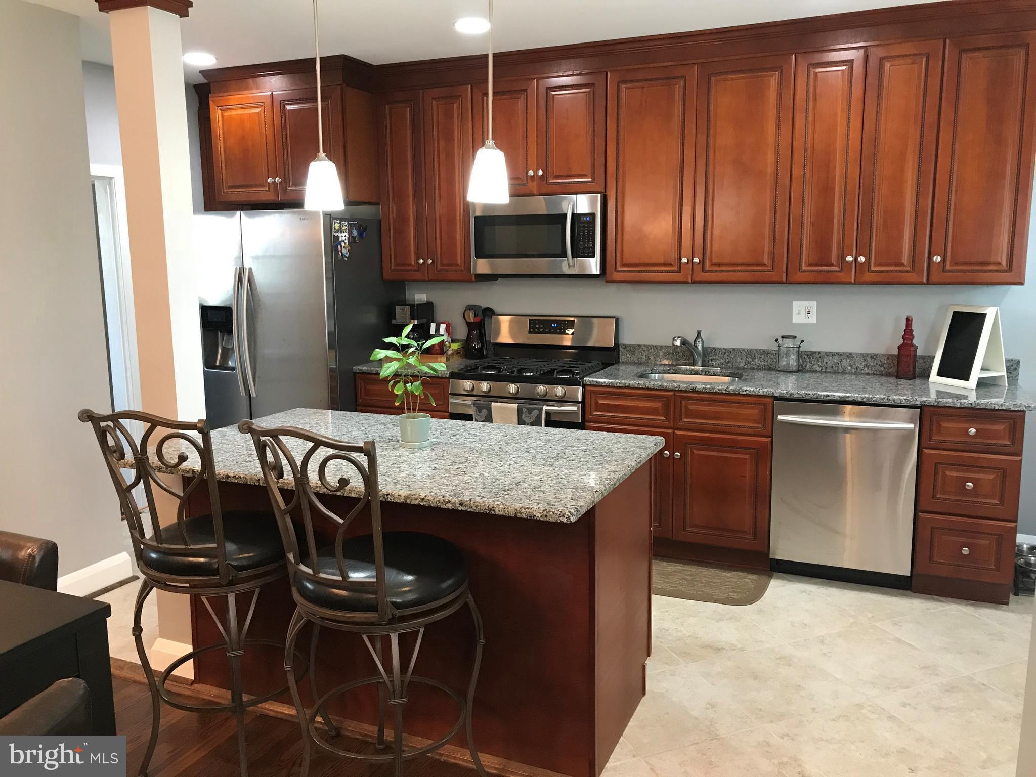 223 Westowne Road Baltimore, MD 21229 - Photo 8 of 21 a kitchen with stainless steel appliances wooden cabinets granite counter tops and a view of living room