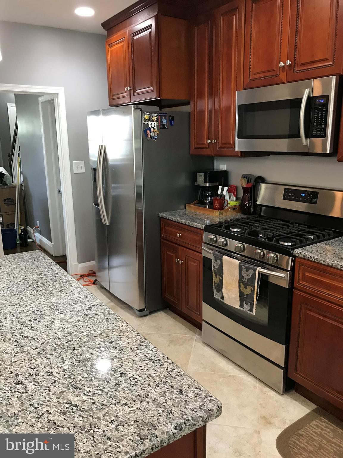 223 Westowne Road Baltimore, MD 21229 - Photo 10 of 21 a kitchen with stainless steel appliances granite countertop a stove a refrigerator and a microwave