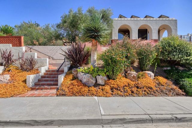 a front view of a house with a garden